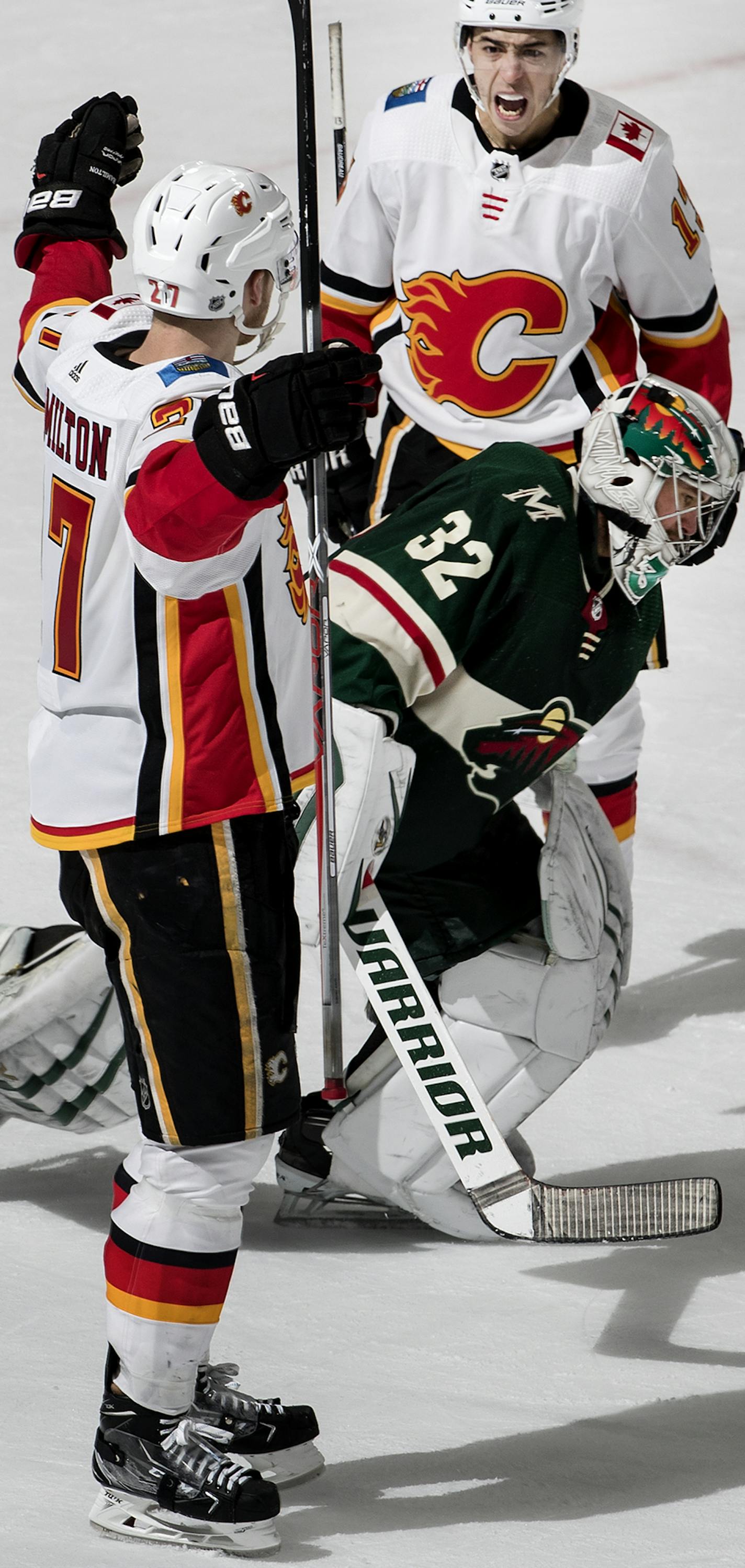 Dougie Hamilton (27) celebrated with Johnny Gaudreau (13) after spring the game winning goal in overtime as Wild goalie Alex Stalock skated off the ice at the end of the game. ] CARLOS GONZALEZ &#xef; cgonzalez@startribune.com - St. Paul, MN - January 9, 2018 - Xcel Energy Center - NHL - Hockey - Minnesota Wild vs. Calgary Flames