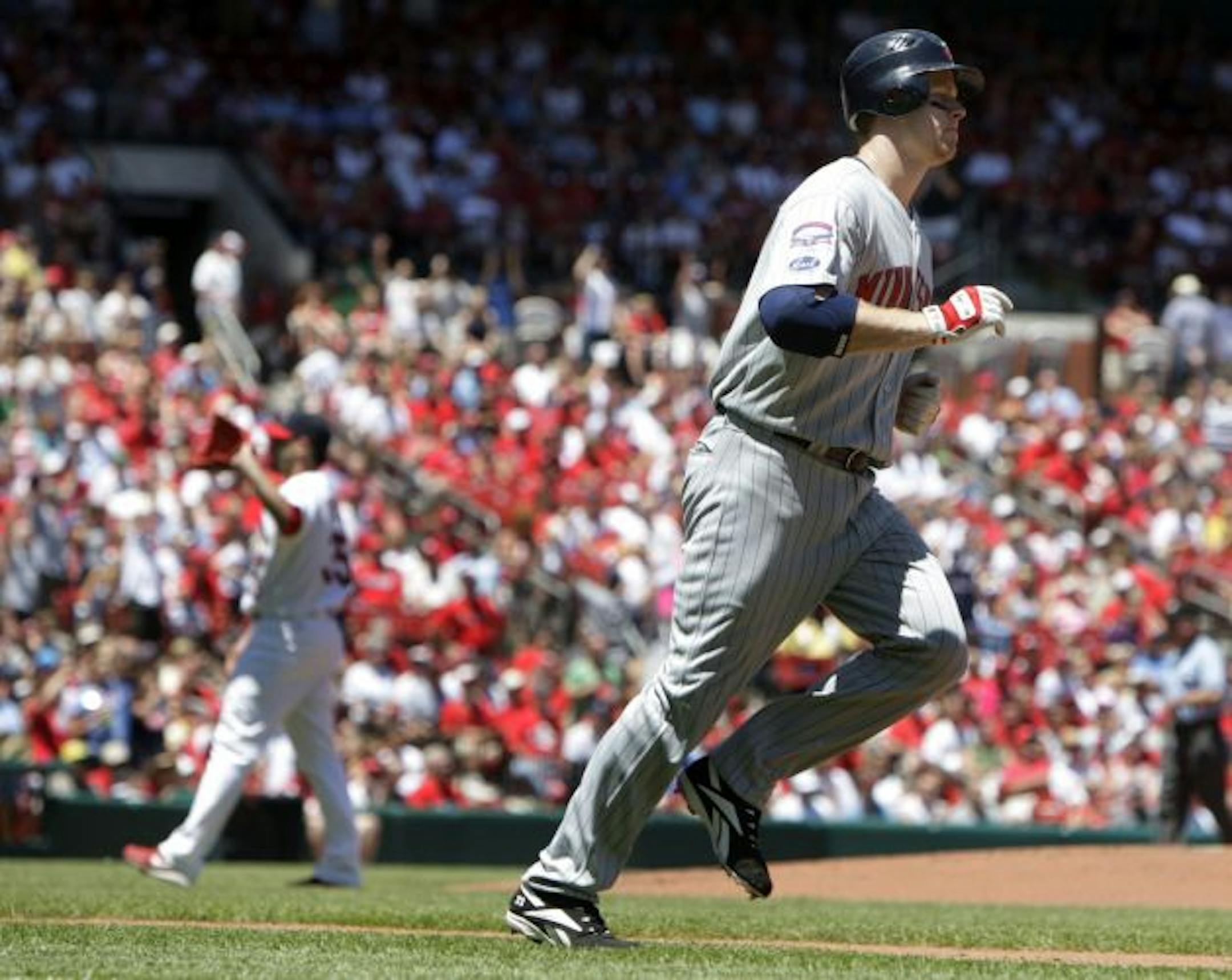 Minnesota Twins' Justin Morneau, right, rounds the bases after hitting a three-run home run off St. Louis Cardinals starting pitcher Joel Pineiro, left, during the first inning of a baseball game Sunday, June 28, 2009, in St. Louis. The Twins won 6-2.