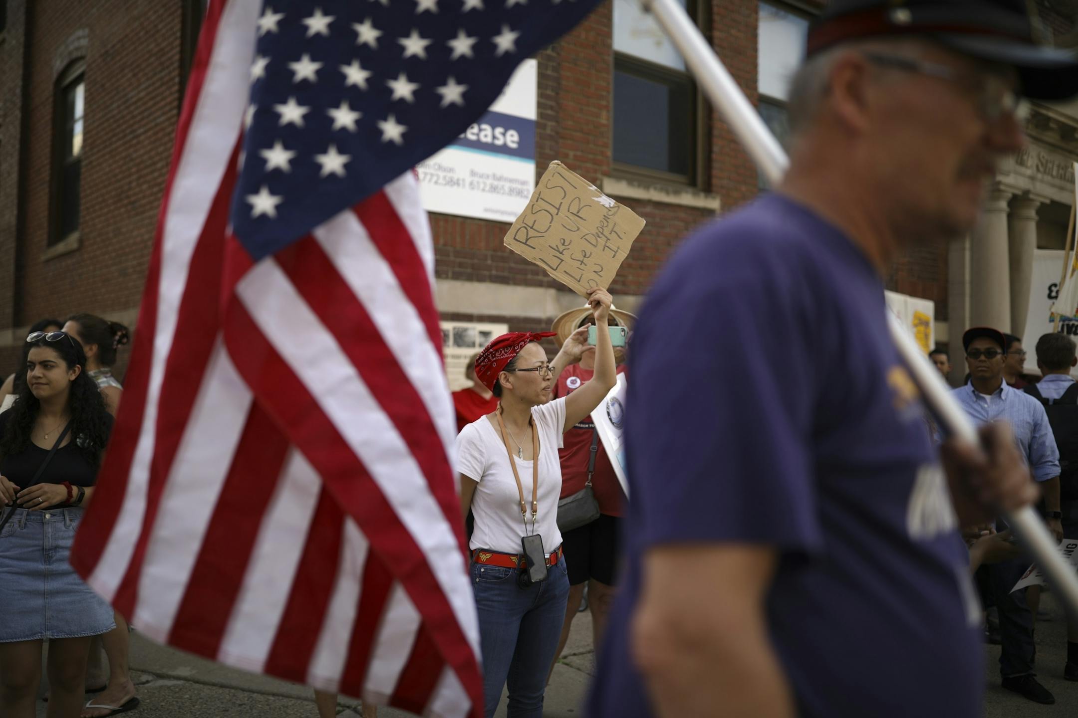 Leah Midgarden held a sign while Mark Freeman carried an American flag upside down to indicate distress while they attended the rally of union workers and supporters in the North Loop Wednesday.