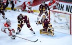 Minnesota Duluth goaltender Hunter Shepard eyed the puck as defenseman Nick Wolff and Ohio State defenseman Tommy Parran (6) battled in front of the n