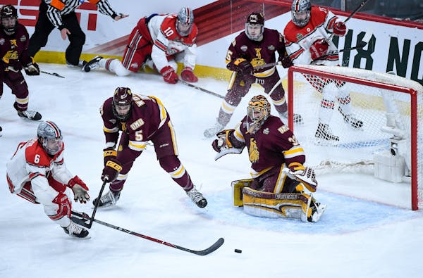 Minnesota Duluth goaltender Hunter Shepard eyed the puck as defenseman Nick Wolff and Ohio State defenseman Tommy Parran (6) battled in front of the n