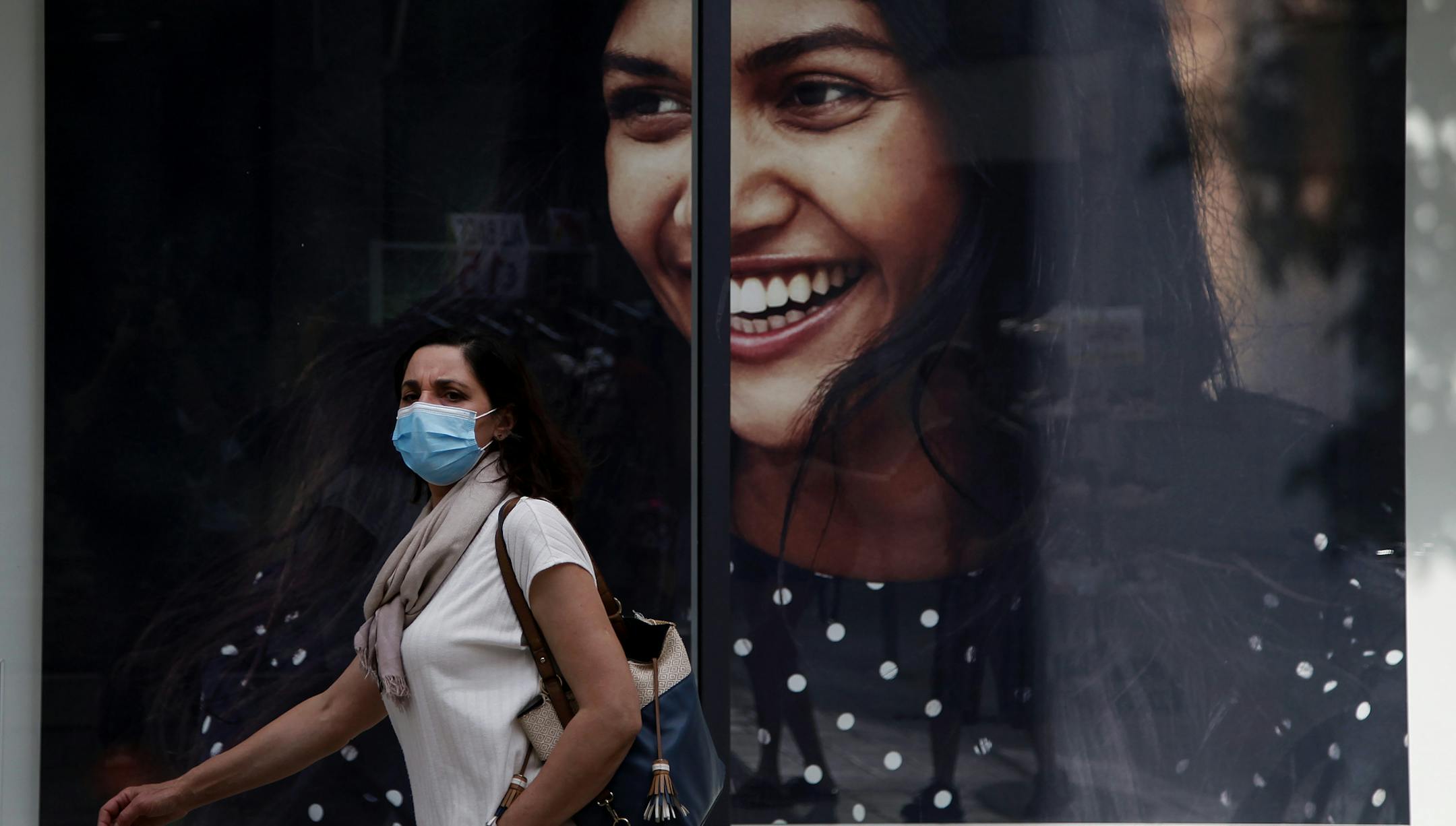 A woman wearing a mask walks along Ledra Street, a busy shopping thoroughfare in the medieval center of capital Nicosia, Cyprus, on Thursday, May 7, 2020. The rhythms of daily life began returning to normal this week as Cypriot government authorities began rolling back a stay-at-home order to contain the spread of the coronavirus, allowing people to go out three times daily although a night time curfew remains in a effect until May 21. (AP Photo/Petros Karadjias)