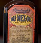 A detail of a patent medicine bottle that says it contains 26.5% alcohol and is “useful for diseases of the blood, stomach, liver, bowels” and mor