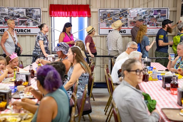 People line up for breakfast inside Hamline Church Dining Hall Thursday, Aug. 24, 2023, at The State Fairgrounds in Falcon Heights, Minn. ]