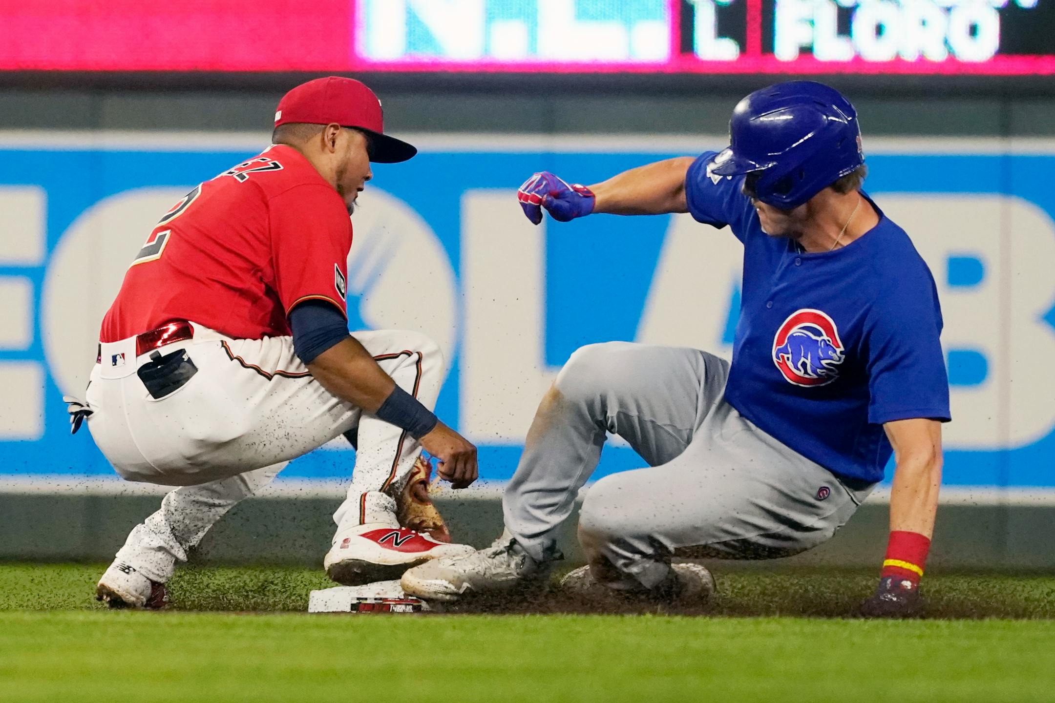 Chicago Cubs' Patrick Wisdom, right, beats the tag by Twins second baseman Luis Arraez in the seventh inning