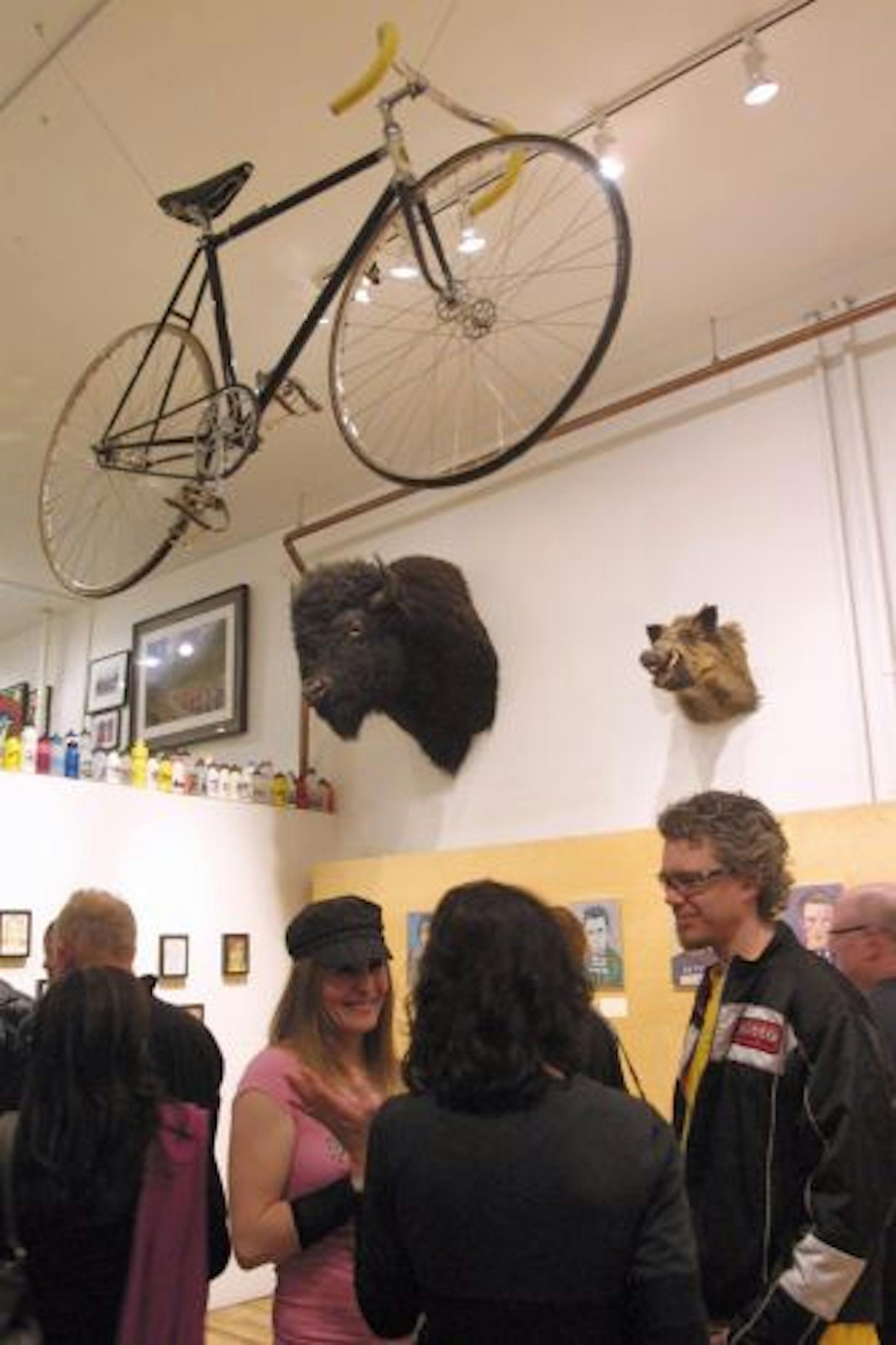 At One on One Bicycle Studio in Minneapolis, bikes hung from the ceiling and the walls to make way for the opening-night crowd for Mary Gibney's art exhibit.