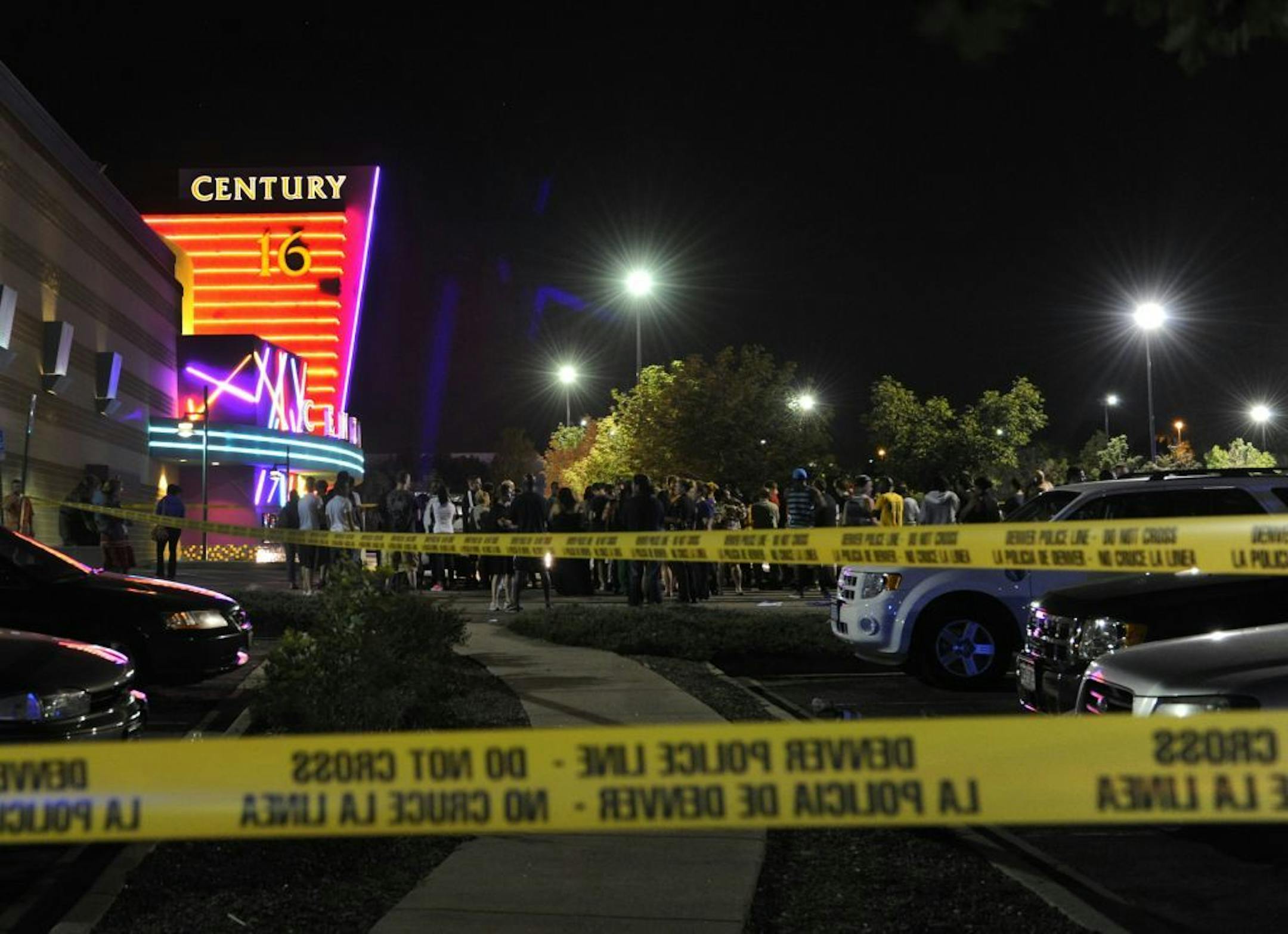 People gather outside the Century 16 movie theatre in Aurora, Colo., at the scene of a mass shooting early Friday morning, July 20, 2012. Police Chief Dan Oates says 14 people are dead following the shooting at the suburban Denver movie theater. He says 50 others were injured when gunfire erupted early Friday at the Aurora theater. Oates says a gunman appeared at the front of one of the Century 16 theaters.