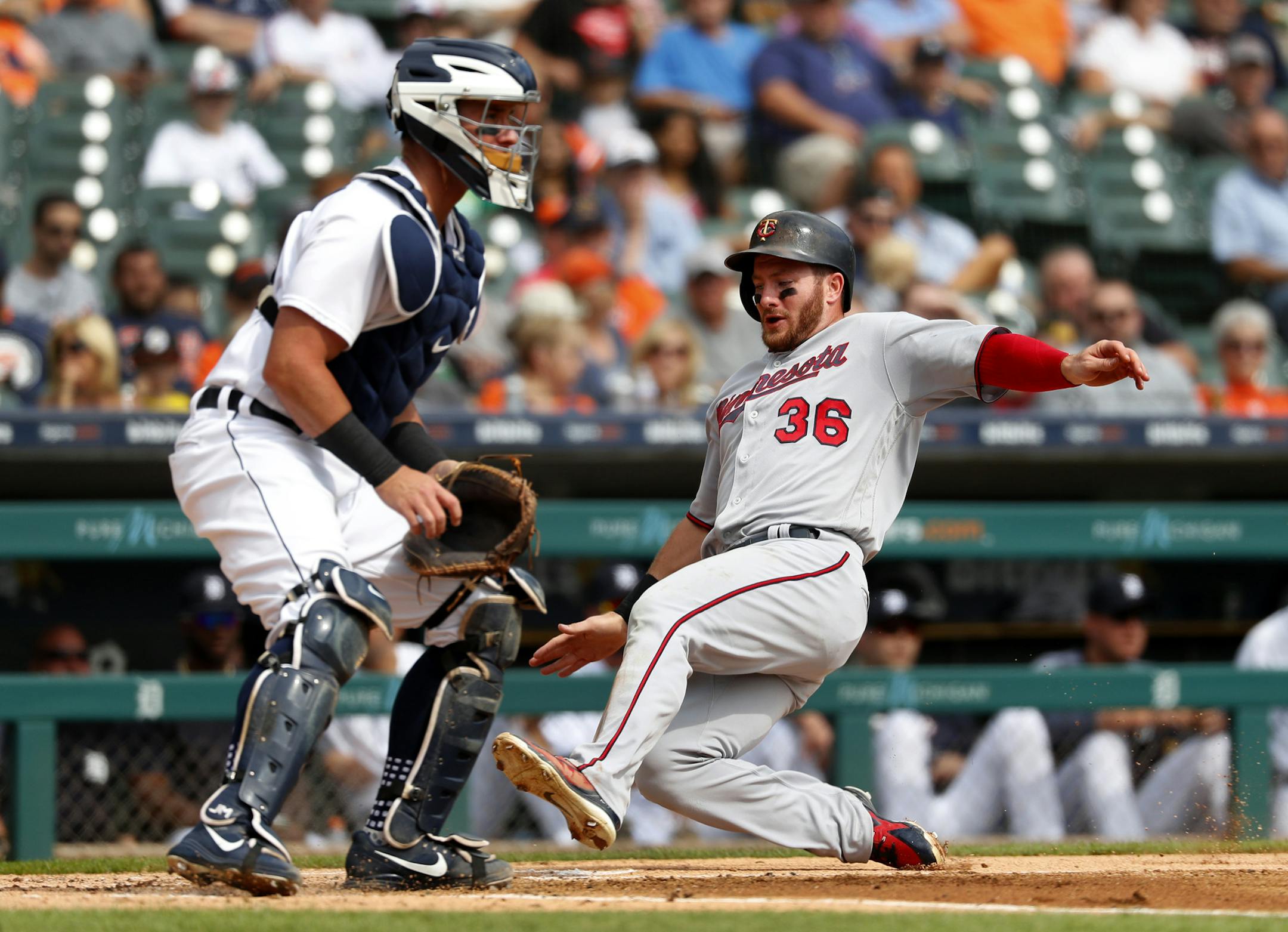 Minnesota Twins' Robbie Grossman (36) scores as Detroit Tigers catcher James McCann waits for the throw at home plate in the second inning of a baseball game in Detroit, Wednesday, Sept. 19, 2018. (AP Photo/Paul Sancya)
