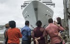 People stand in front of an MSC Cruises ship docked in Havana, Cuba, on Jan. 27, 2018. MUST CREDIT: Bloomberg photo by Francesco Pistilli.