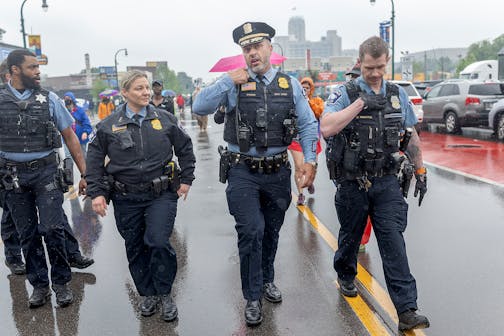 Minneapolis Police Chief Brian O’Hara, second from right, makes his way down W. Lake Street amid protests over a federal raid in south Minneapolis on June 3.
