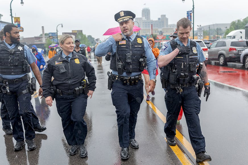 Minneapolis Police Chief Brian O’Hara, second from right, makes his way down W. Lake Street amid protests over a federal raid in south Minneapolis on June 3.