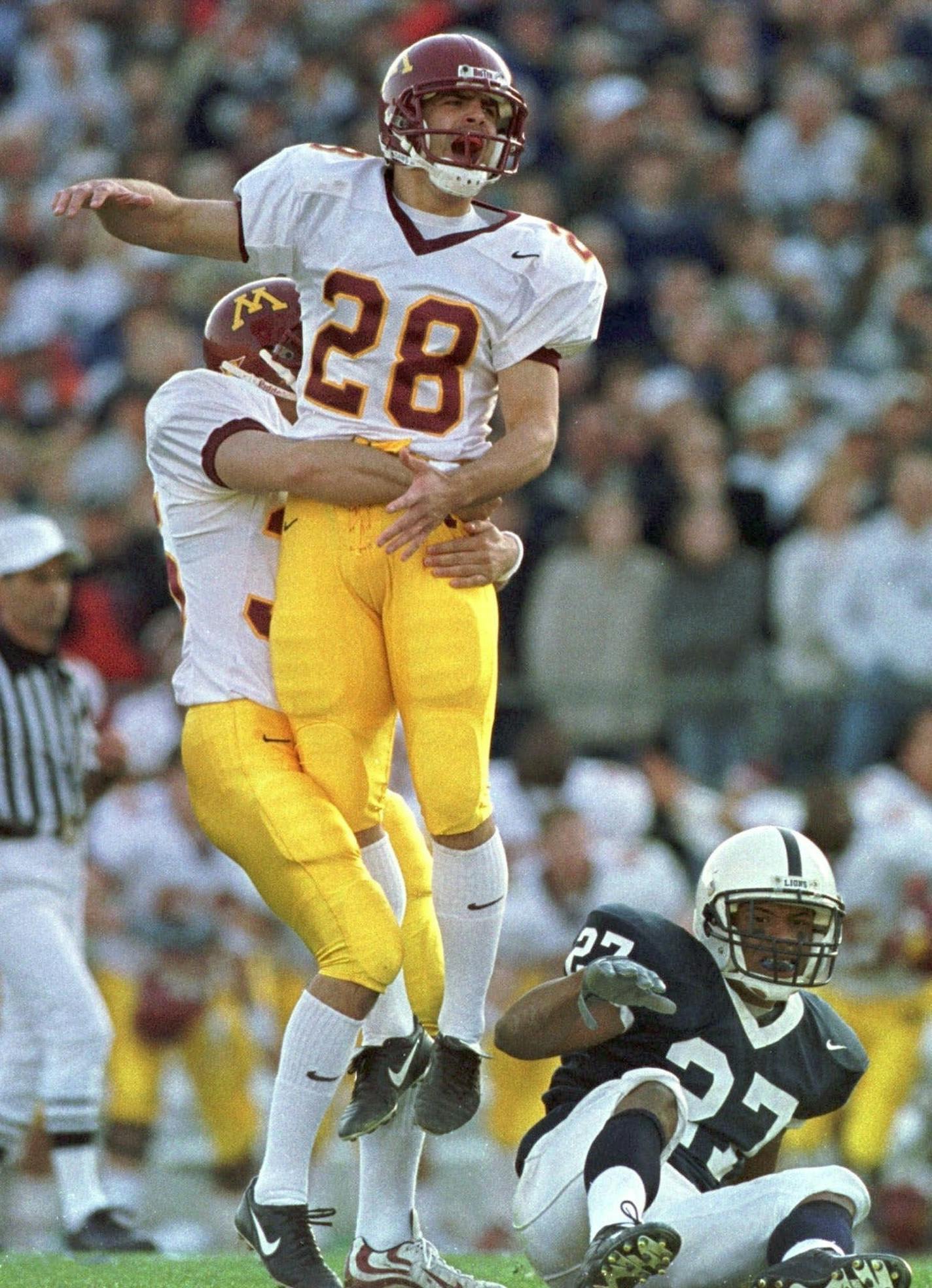 Minnesota kicker Dan Nystrom jumps into the arms of holder Ryan Rindels after he kicked a field goal with two seconds left on the game clock Saturday, Nov. 6, 1999, for a 24-23 win over Penn State at Beaver Stadium in State College, Pa. Penn State's David Macklin sits on the field, right. (AP Photo/Pittsburgh Post-Gazette, John Beale)