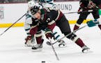 Arizona Coyotes center Nick Bjugstad (17) gets hooked by San Jose Sharks right wing Kevin Labanc (62) during the first period of an NHL hockey game in