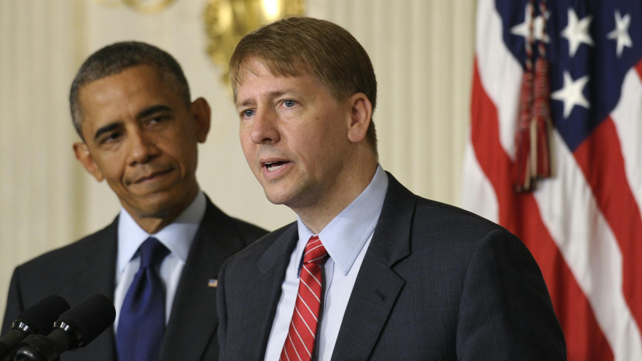 President Barack Obama, left, listens as Richard Cordray, right, the new director of the Consumer Financial Protection Bureau, speaks in the State Dining Room of the White House in Washington, Wednesday, July 17, 2013. The Senate voted on Tuesday, July 16, 2013, to end a two-year Republican blockade that was preventing Cordray from winning confirmation as director of the Consumer Financial Protection Bureau. (AP Photo/Susan Walsh) ORG XMIT: MIN2013071914570248