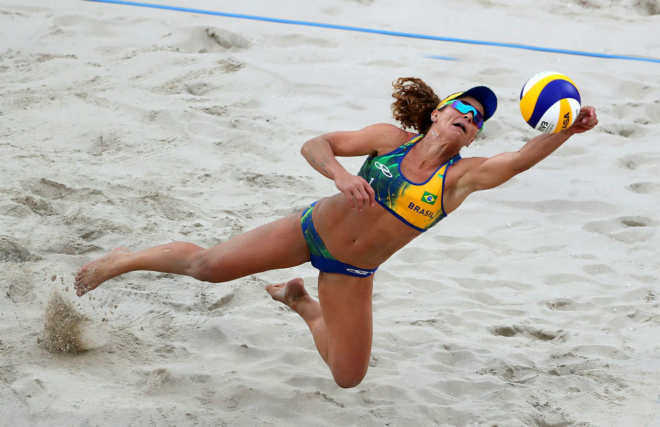 The beach volleyball venue is the centerpiece of the Rio games, situated right on Copacabana Beach, it attracts large crowds both inside and on the beach (left) Tuesday night was a big night for Brazil with two semifinal matches, women and men. Here, Brazil's Larissa Franca Maestrini dives for a ball near the back of the court.