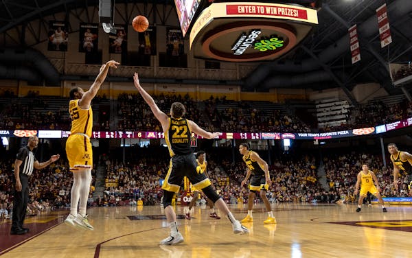 Ta'Lon Cooper (55) of the Minnesota Gophers makes a three pointer in the first half.
