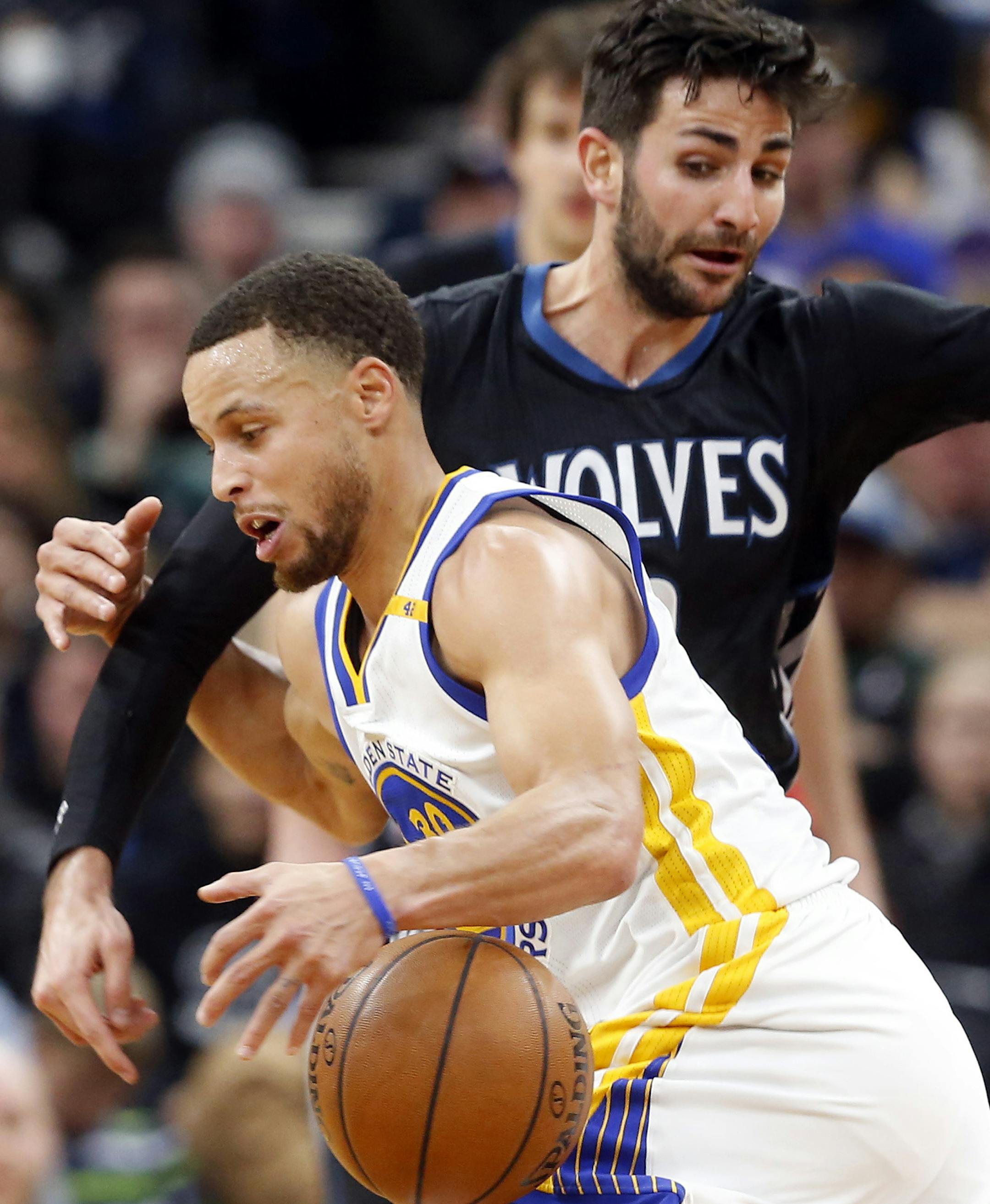 Golden State Warriors' Stephen Curry, center, right, gets tied up with Minnesota Timberwolves' Ricky Rubio of Spain during the first half of an NBA basketball game Friday, March 10, 2017, in Minneapolis. (AP Photo/Jim Mone)