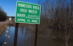 A sign along the flooded Minnesota River on March 20, 2019, near Belle Plaine, Minn. As much of the state braces for the potential flooding of yet ano