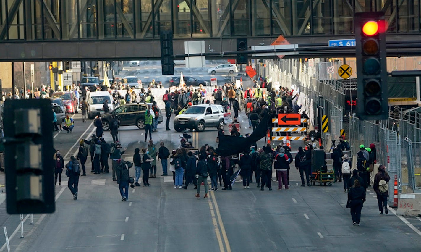 Protestors gather on 3rd Avenue on the north side of the Hennepin County Government Center before marching as the trial of fired Minneapolis police officer Derek Chauvin begins Monday in Minneapolis. ]