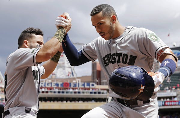 Houston Astros' Carlos Correa, right, is congratulated by Jose Altuve following his solo home run off Minnesota Twins pitcher Ervin Santana, left, in 