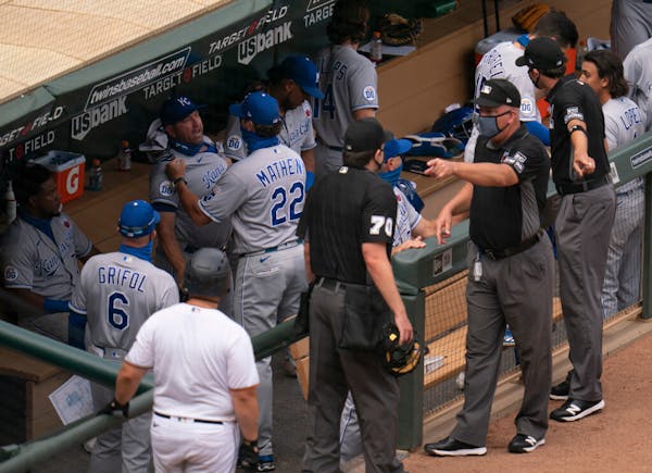 Kansas City Royals manager Mike Matheny (22) restrained third base coach Vance Wilson after he had words with the umpires following Sunday's game.