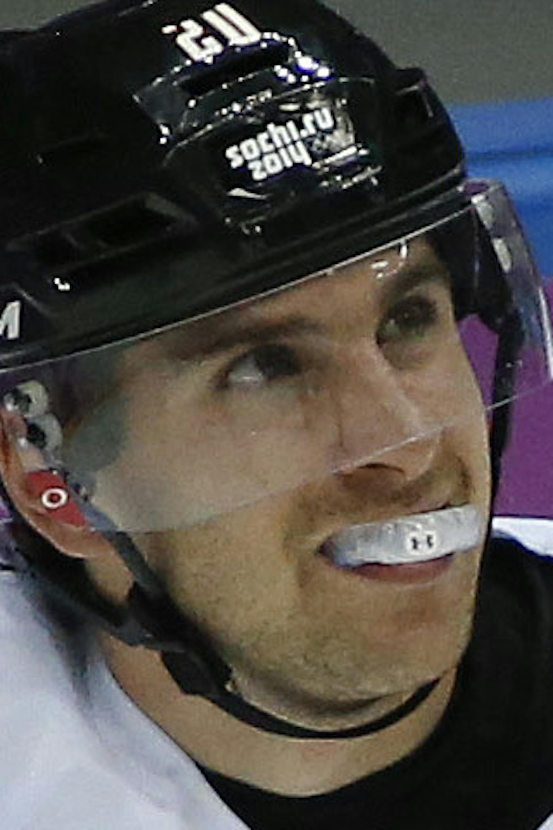 Canada forward John Tavares skates off the ice with a trainer after sustaining a leg injury during the second period of a men's quarterfinal ice hockey game against Latvia at the 2014 Winter Olympics, Wednesday, Feb. 19, 2014, in Sochi, Russia. Tavares is out for the rest of the Olympics. (AP Photo/Mark Humphrey)