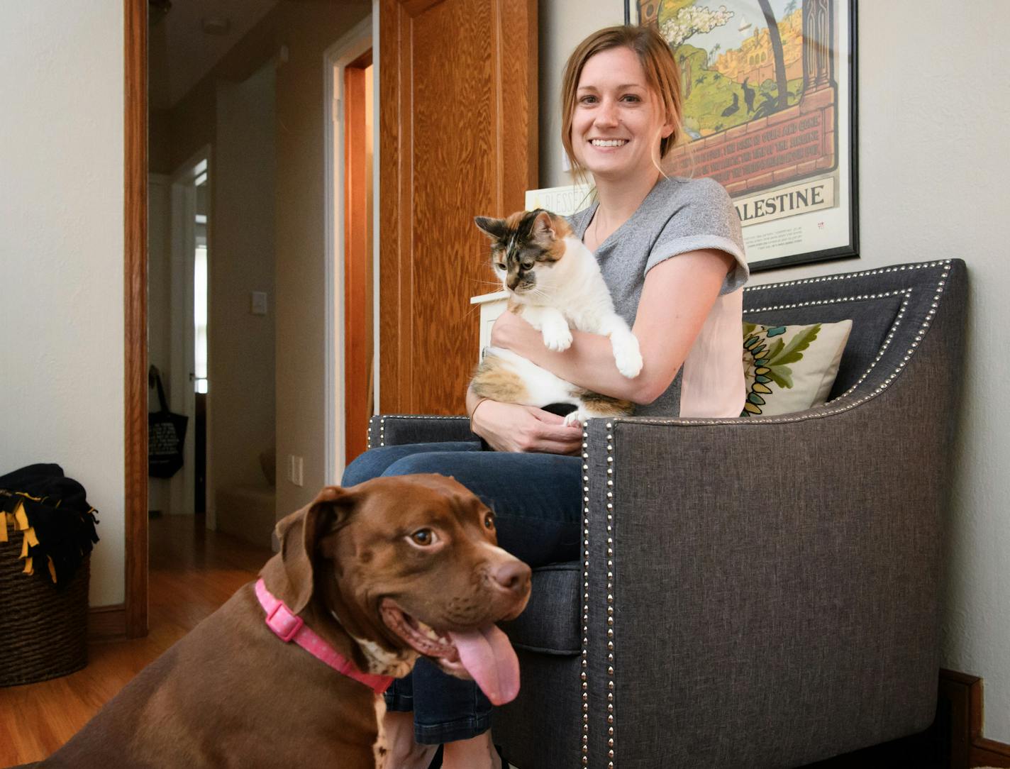 Christine Hinrichs with her rescue pets, pit bull mix Olive, 5, and one of her cats, Ruby, 7. Hinrichs is a volunteer for Pet Project Rescue.