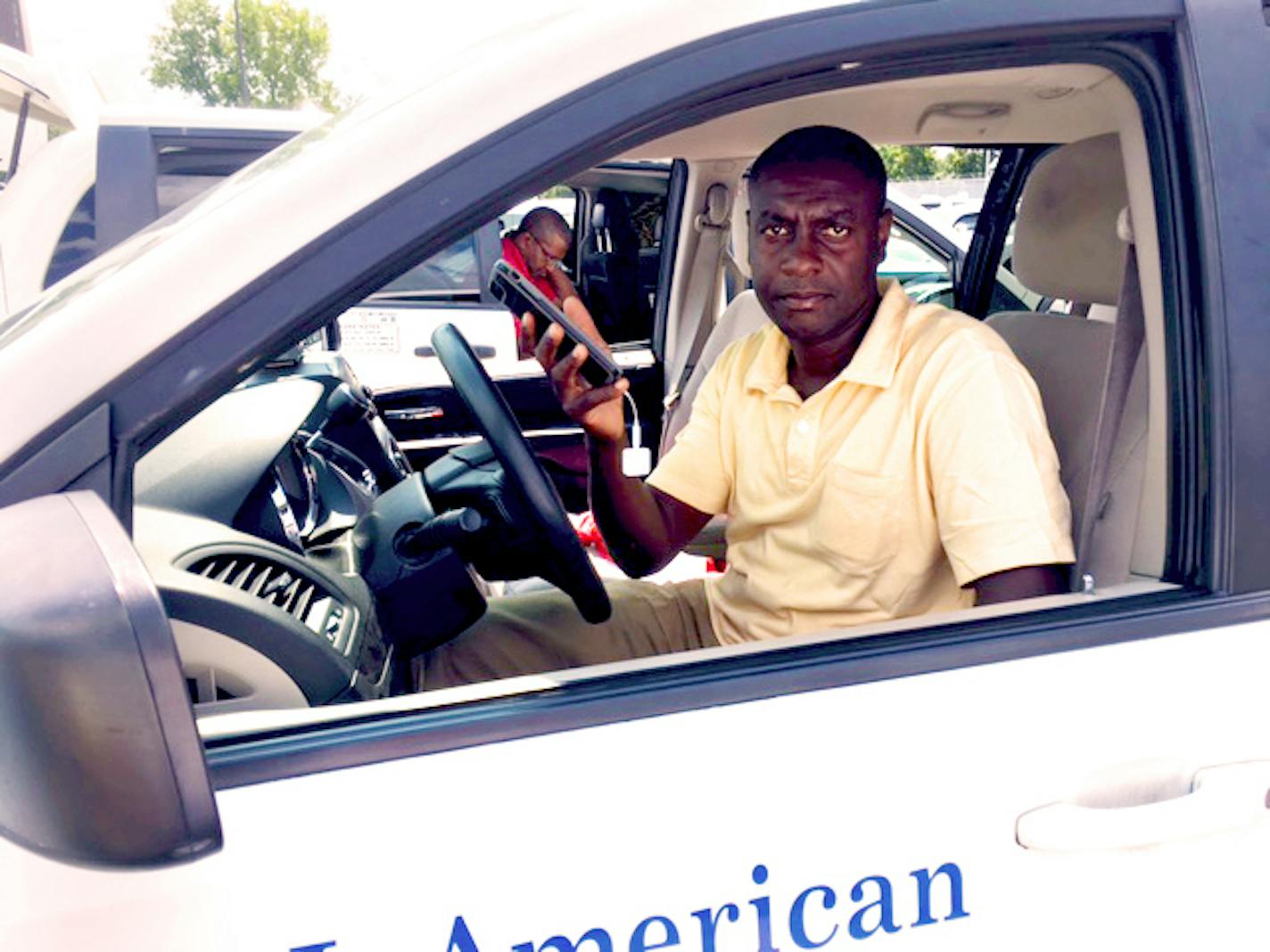 Cab driver Komlan Akakpo shows the Square smartphone device he uses in his cab at Minneapolis-St. Paul International Airport.