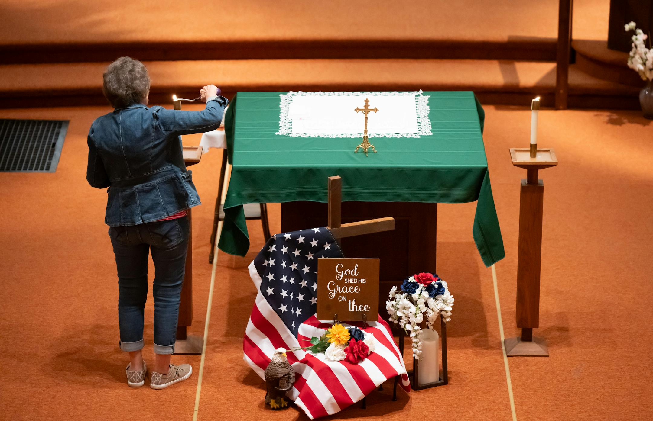 Madona Adelman lit candles at the start of Friday Mass at St. Joseph Church.