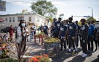 Timberwolves players, coaches, and staffers listened to Jeanelle Austin, left, as she explained and interpreted the memorial site for the group. The f