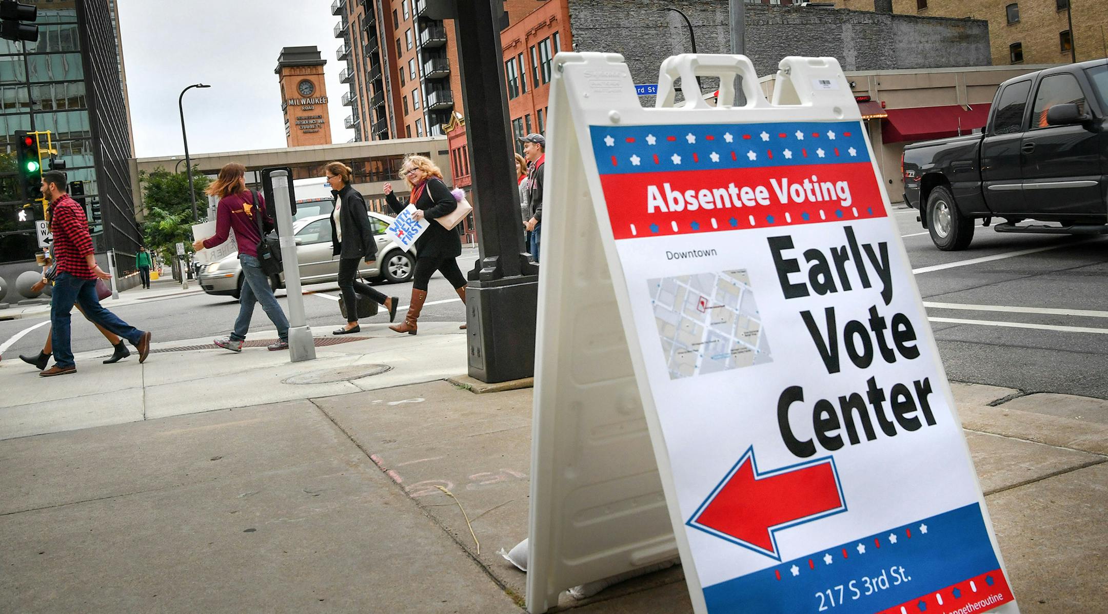 People walk from the Democratic-Farmer-Labor Party's early voting rally to a voting center in Minneapolis Friday, Sept. 23, 2016. Friday kicked off the state's early voting period, making Minnesota among the first states to open up voting. It's the state's second election with early voting as an option but the first during a presidential contest. (Glen Stubbe/Star Tribune via AP) ORG XMIT: MIN2016110313354013