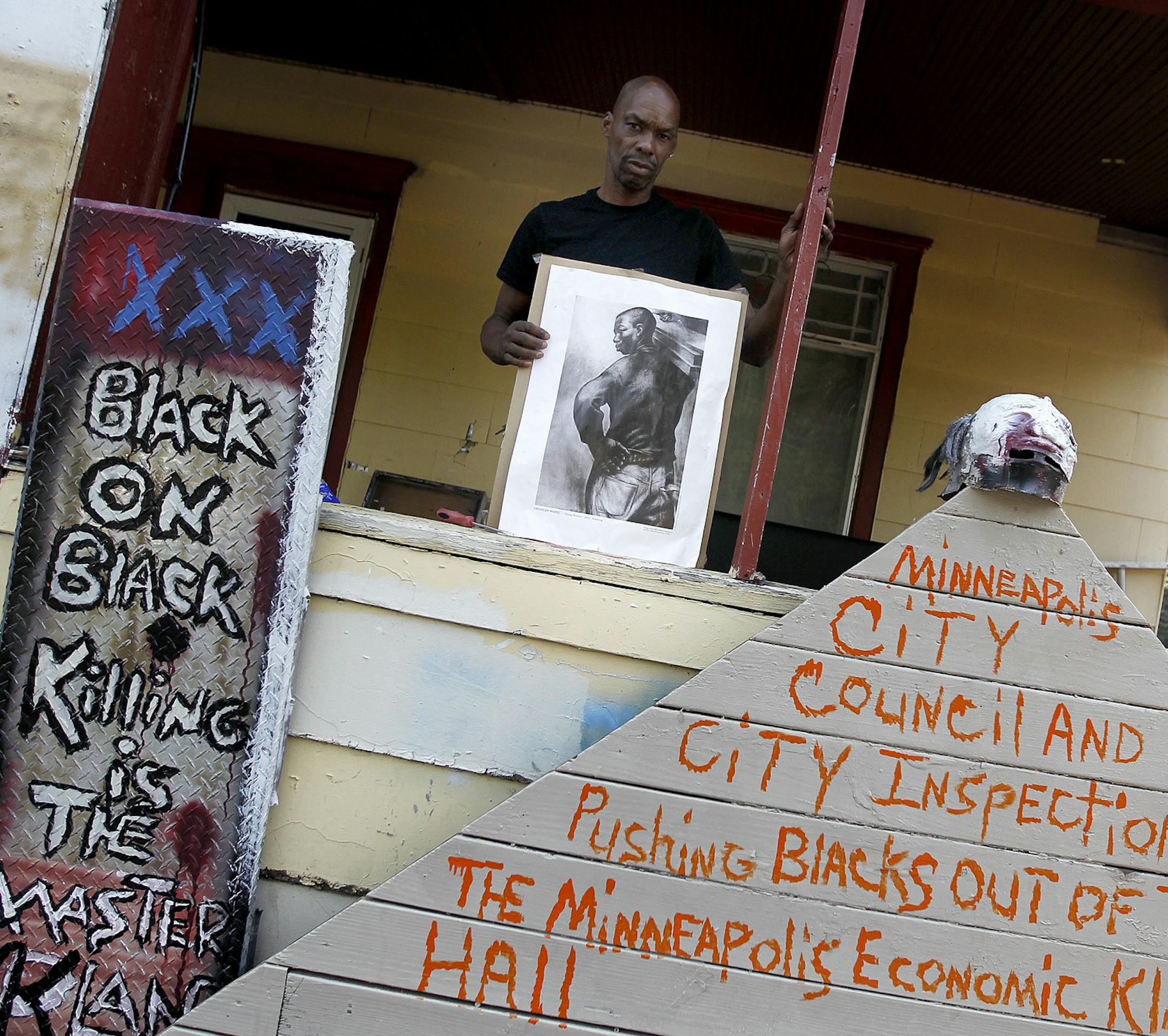Andrew Moore sifted through pieces of art that he has to rid of, Wednesday, August 21, 2013 in Minneapolis, MN. Powderhorn Park lawn artist, enemy of City Hall and homeowner Andrew Moore may get thrown out of his house at 3255 Bloomington Ave. S. as city officials move to condemn the property. He's long fought with city officials over his front yard art display, a collection of political signs, things pulled from the trash and other odds and ends, but mostly odds. (ELIZABETH FLORES/STAR TRIBUNE)