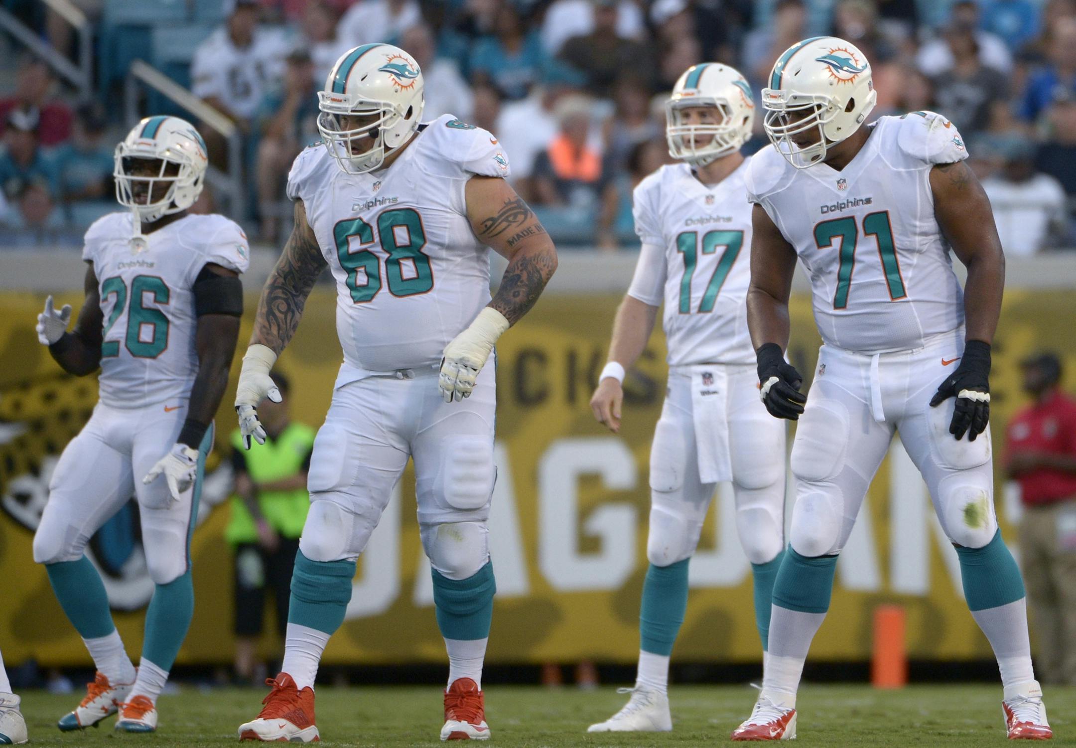 Miami Dolphins guard Richie Incognito (68) and tackle Jonathan Martin (71) set up to block as quarterback Ryan Tannehill (17) and running back Lamar Miller (26)check the defense during the first half of an NFL preseason football game against the Jacksonville Jaguars in Jacksonville, Fla., Friday, Aug. 9, 2013.(AP Photo/Phelan M. Ebenhack)