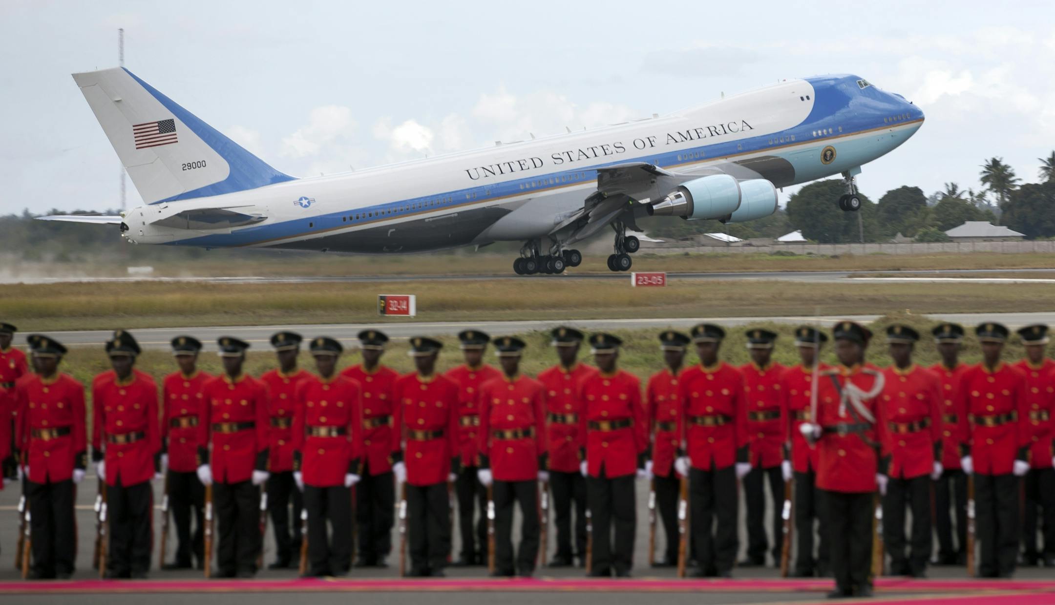 Air Force One takes off as a Tanzanian honor guard stands to attention, as U.S. President Barack Obama finishes the final leg of his weeklong visit to Africa, at the Julius Nyerere airport in Dar es Salaam, Tanzania Tuesday, July 2, 2013.