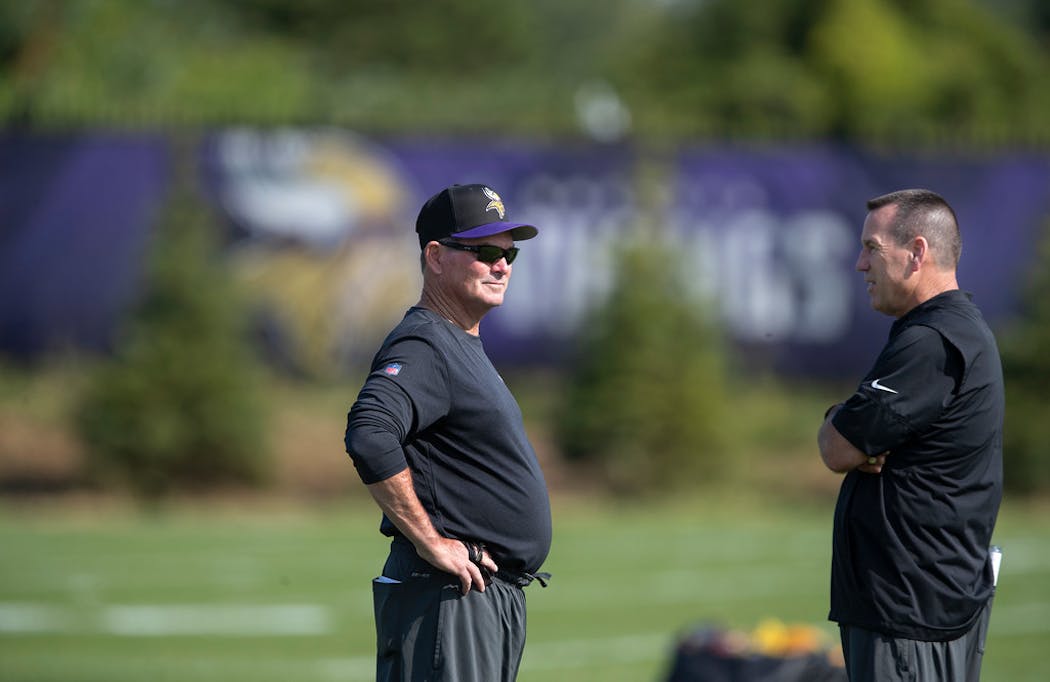 Mike Zimmer, left, and Gary Kubiak talked during the first day of rookie camp during the spring.