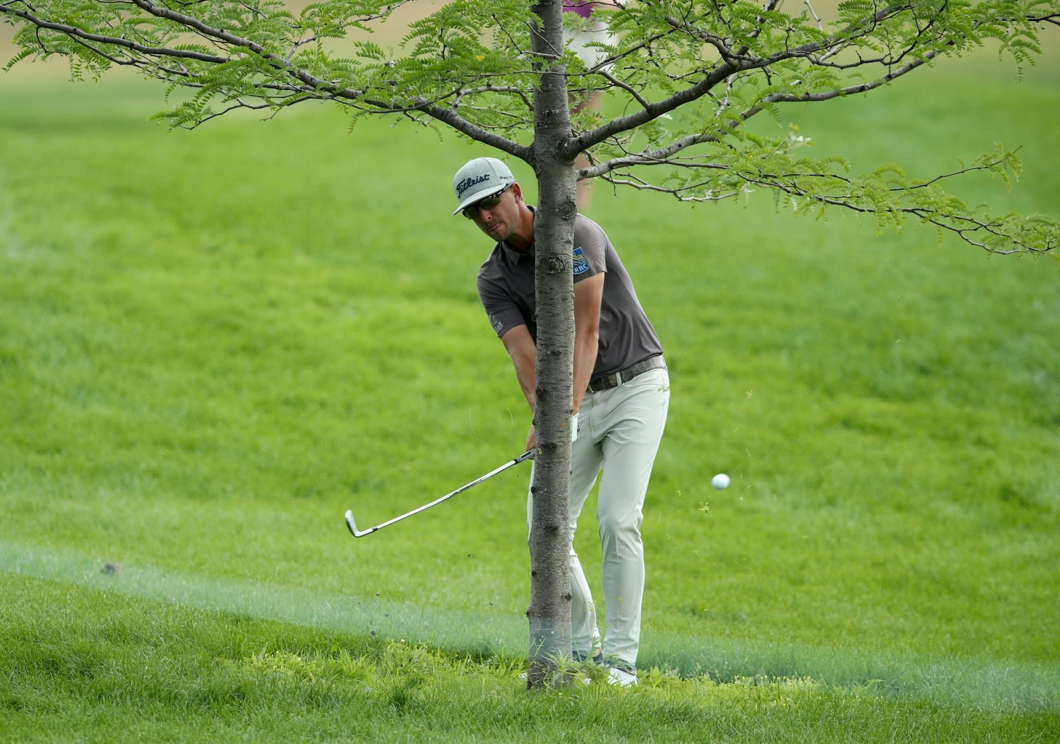 Roger Sloan hits around a tree on the 1st hole during the final day of the 3M Open at TPC Twin Cities.