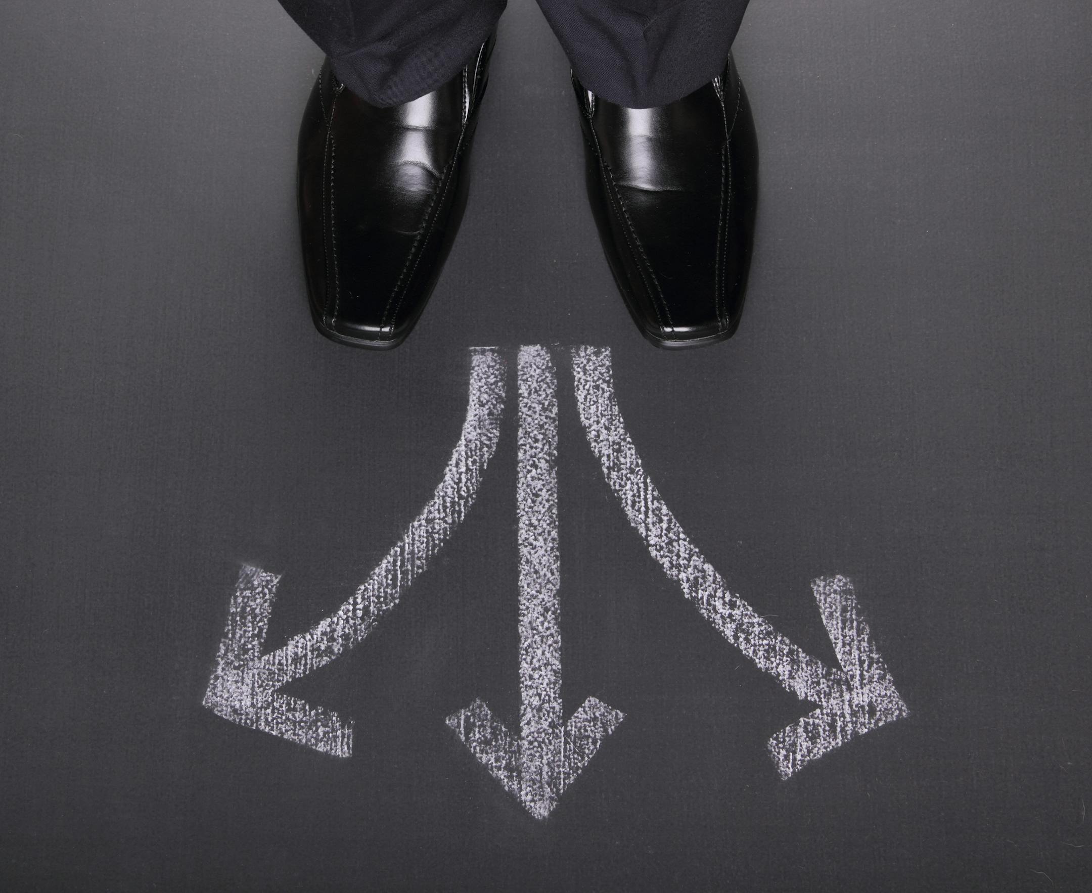 Unrecognizable businessman standing in front of three arrows showing different waysSome other related images: