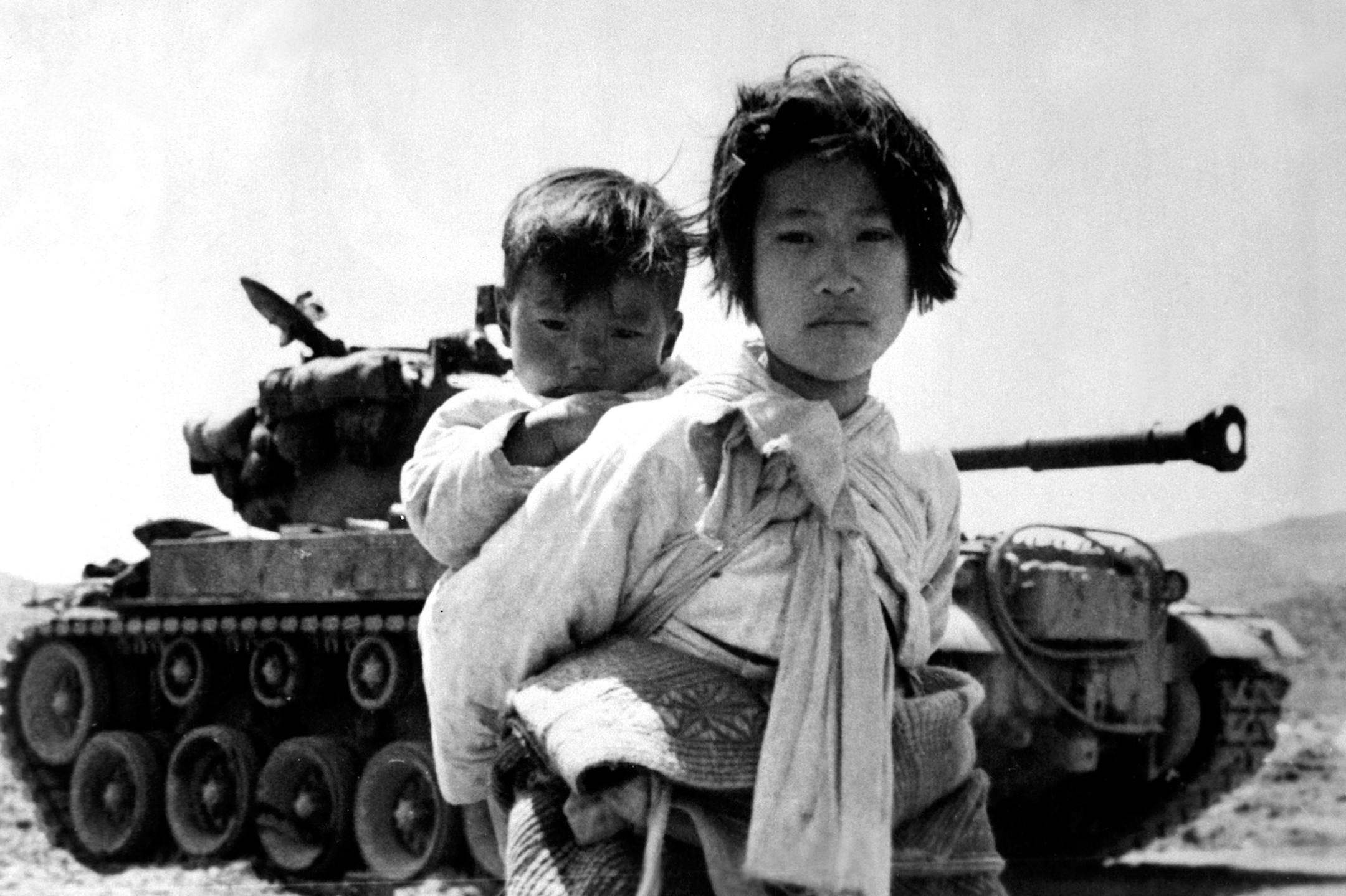 With her brother on her back a war weary Korean girl tiredly trudges by a stalled M-26 tank, at Haengju, Korea. June 9, 1951. Maj. R.V. Spencer, UAF. (Navy)
From "Korea: The Never-Ending War"