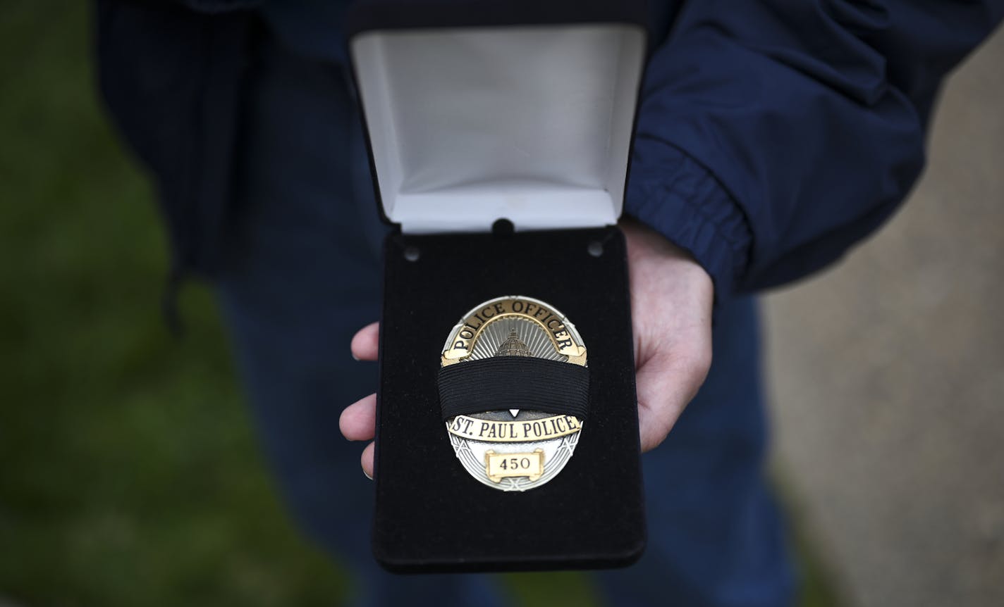 Jim Sackett Jr., son of slain St. Paul Police Officer James Sackett, held the badge that St. Paul Police Chief Todd Axtell presented the family Friday. ] aaron.lavinsky@startribune.com Jeanette Sackett can't go one day without thinking about what she's lost. It's been 50 years since her police officer husband, James Sackett, was slain in an ambush, but the pain has not subsided. On Friday, St. Paul police and other law enforcement agencies commemorated the anniversary with a procession outside h