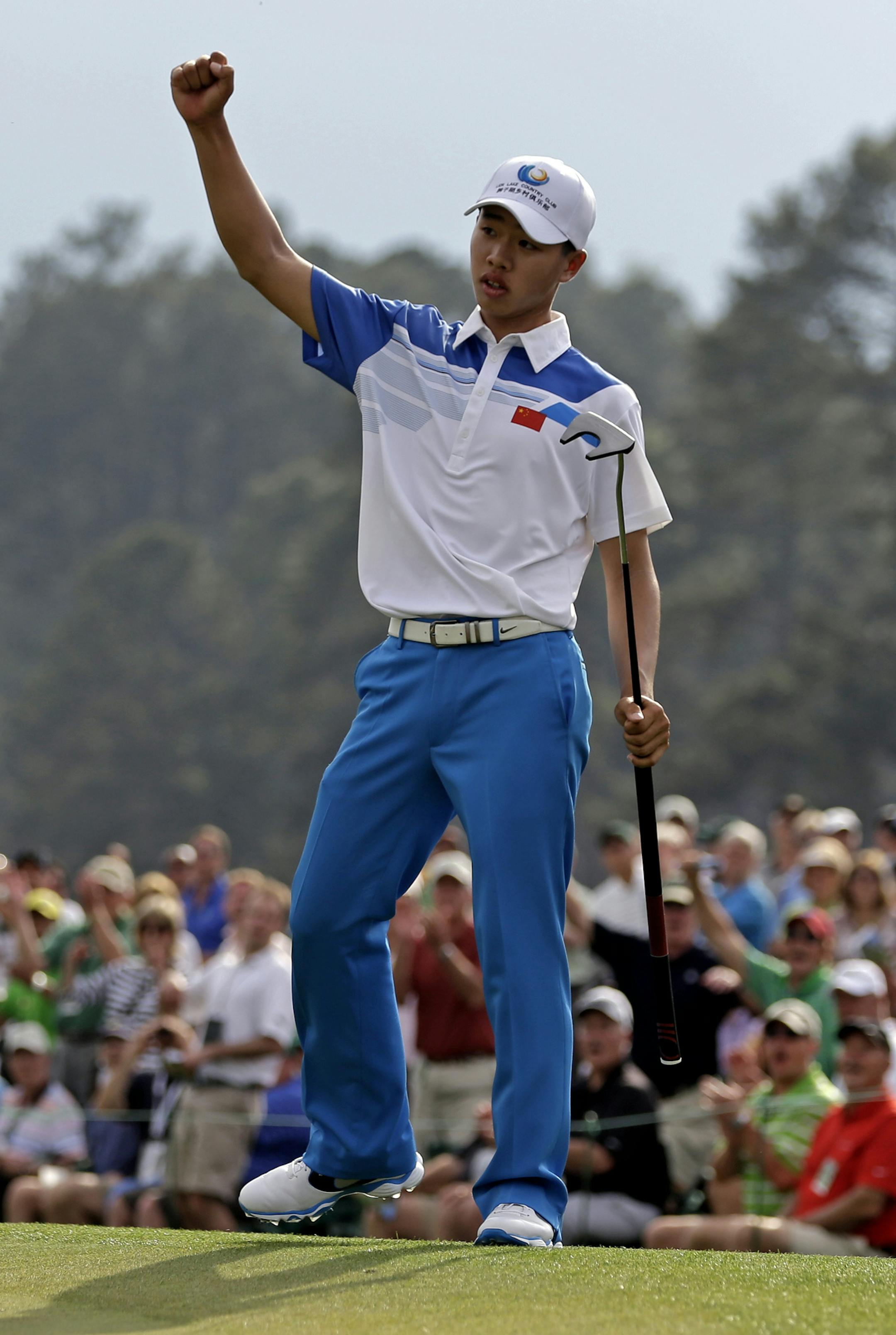 Amateur Guan Tianlang, of China, celebrates after a birdie putt on the 18th green during the first round of the Masters golf tournament Thursday, April 11, 2013, in Augusta, Ga. (AP Photo/Darron Cummings)