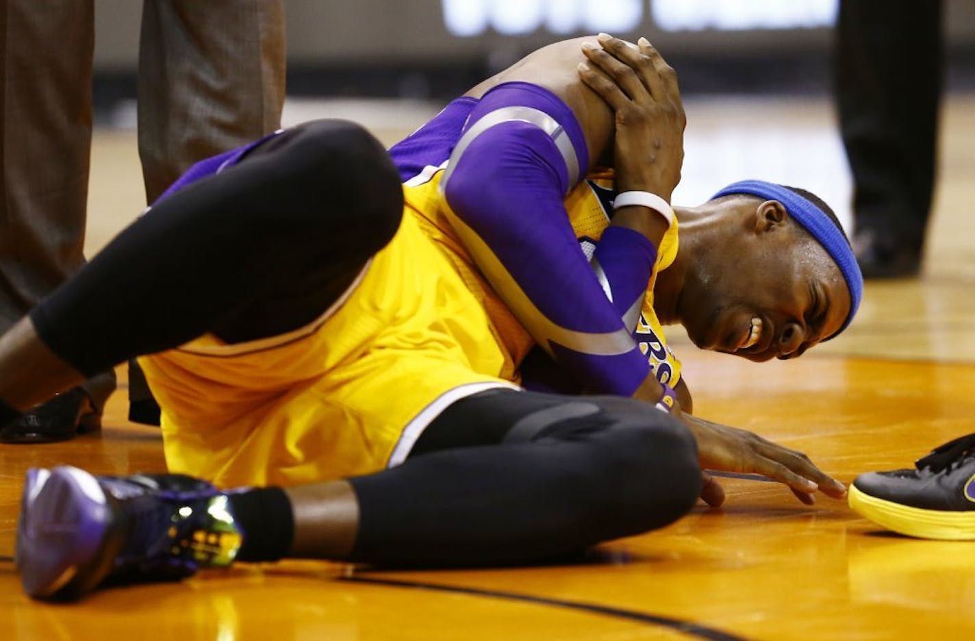 L.A. Lakers Dwight Howard falls to the court and grabs his right shoulder in pain in the 4th quarter of the game against the Phoenix Suns Wednesday Jan. 30, 2013. The Lakers, who had won three straight _ all at home, lost Dwight Howard when he reinjured his right shoulder with 6:57 to play.