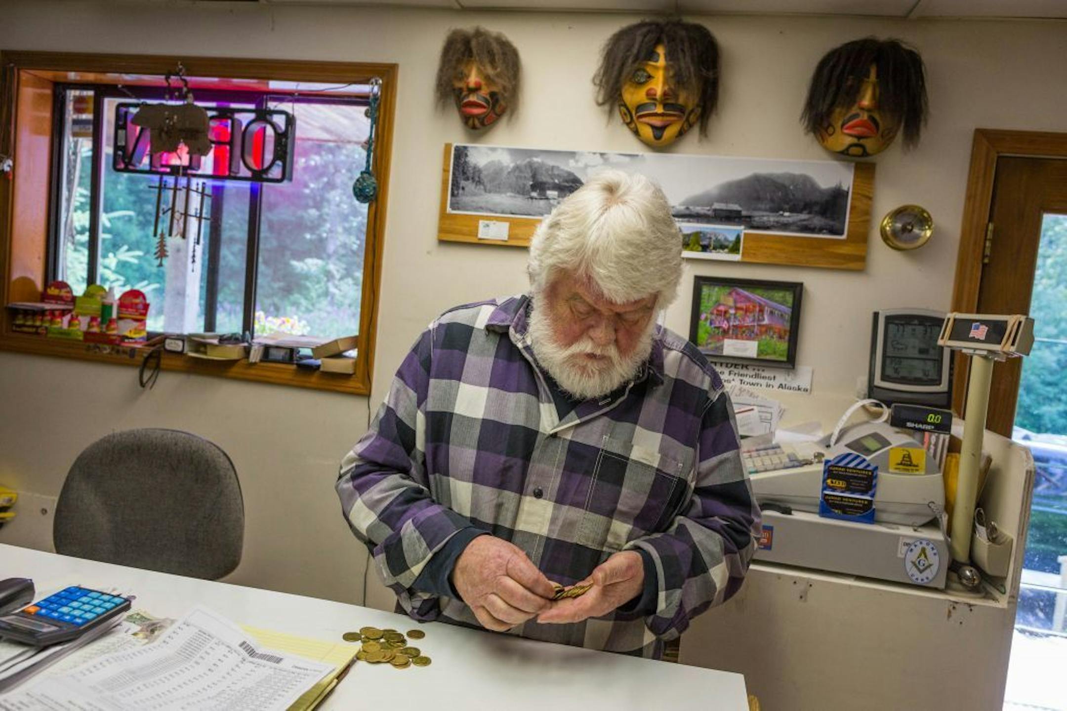 ADVANCE FOR WEEKEND EDITIONS, JULY 24-26 In this July 3, 2015, photo, Hyder General Store owner Wes Loe counts loonies, Canadian one dollar coins, in his shop in Hyder, Alaska. (Loren Holmes/Alaska Dispatch News via AP) KTUU-TV OUT; KTVA-TV OUT; THE MAT-SU VALLEY FRONTIERSMAN OUT; MANDATORY CREDIT