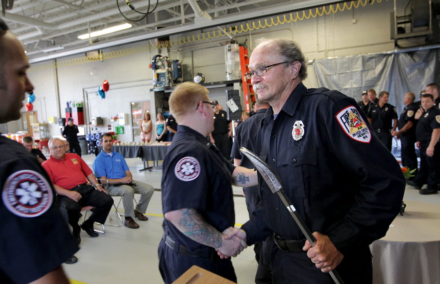 Firefighters line up to shake the hand of Jeff Davis after he received multiple awards in honor of 40 years of exemplary service as a paid-on-call volunteer firefighter at Fire Station 3 in Inver Grove Heights July 14, 2013. Davis, who just completed his 33rd Grandma's Marathon, has no plans yet to quit being a firefighter. (Courtney Perry/Special to the Star Tribune)