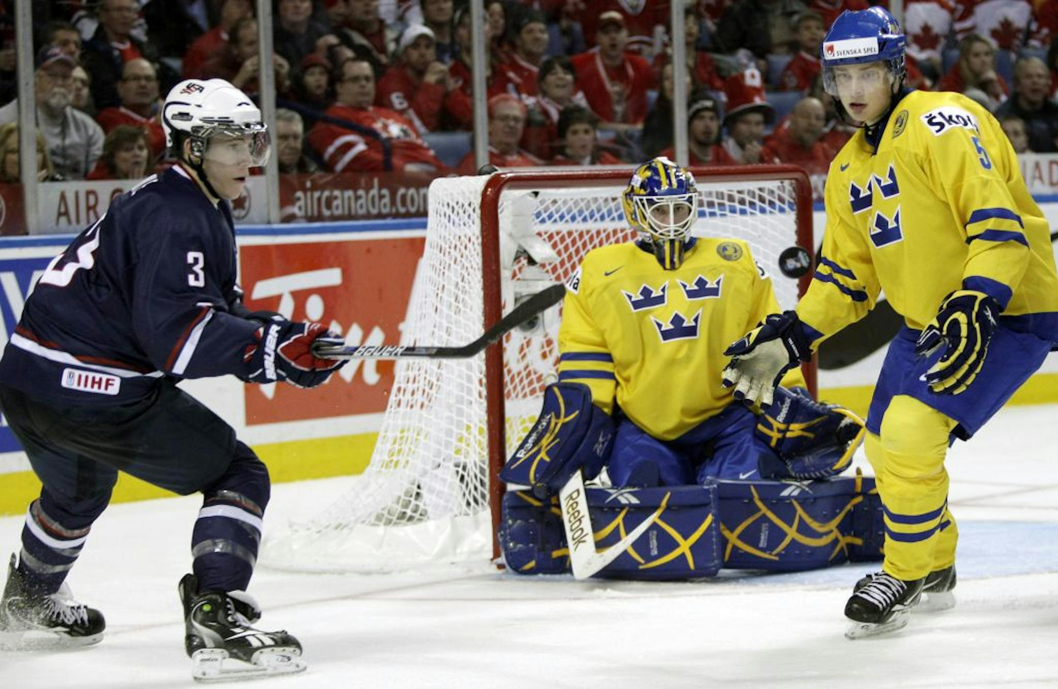 Sweden's Adam Larsson (5) defends against a shot by Team USA's Charlie Coyle (3) in front of Sweden goalie Fredrik Petersson Wentzel during the second period of a World Junior Hockey Championship bronze medal game in Buffalo, N.Y., Wednesday, Jan. 5, 2011.