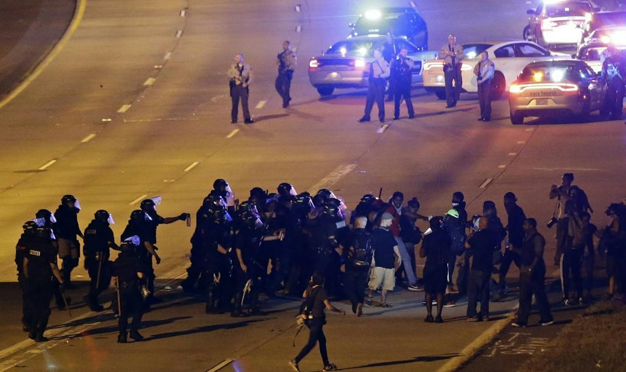 Police confront protesters blocking I-277 during a third night of unrest following Tuesday's police shooting of Keith Lamont Scott in Charlotte, N.C., Thursday, Sept. 22, 2016.