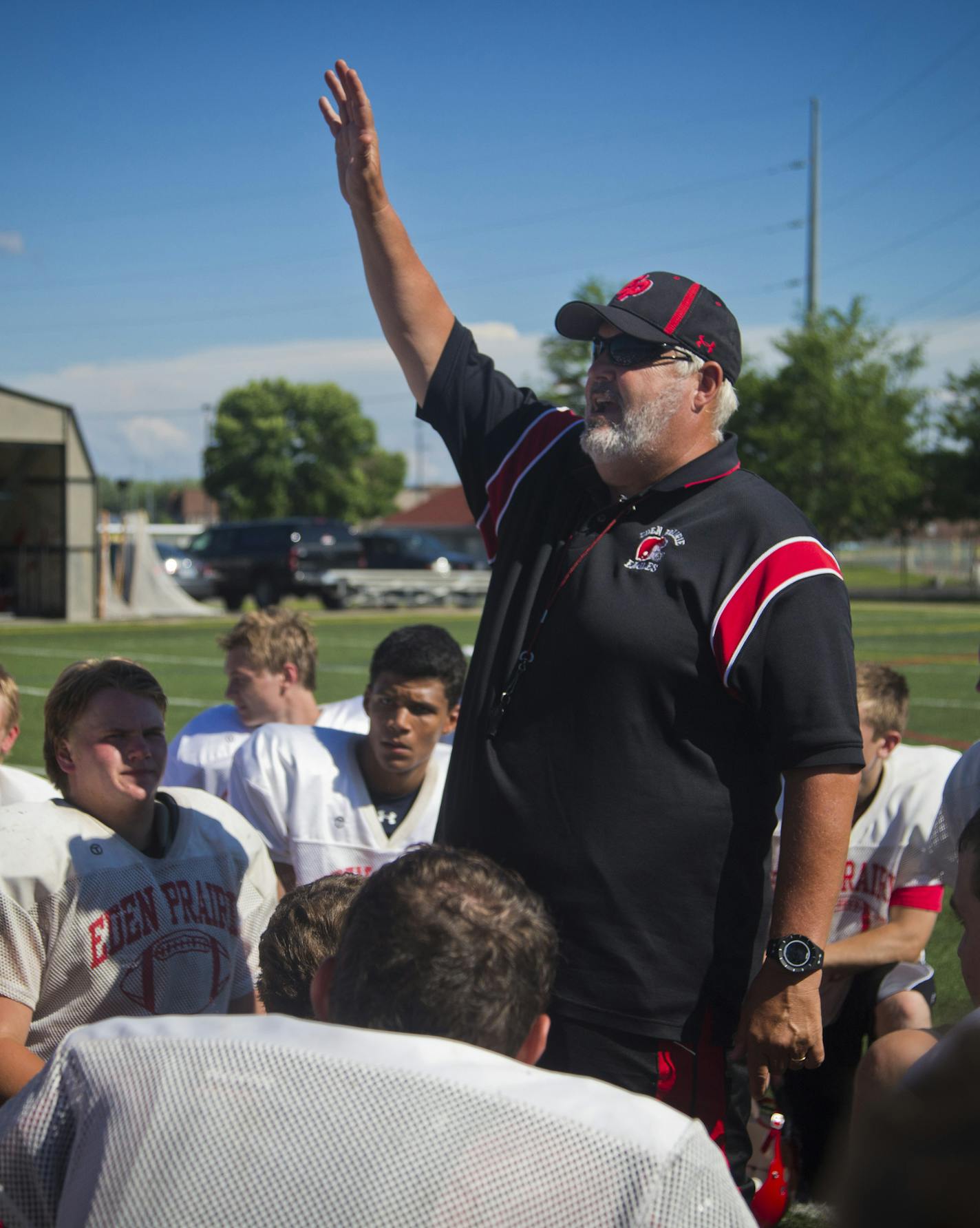 Eden Prairie head coach Mike Grant told his players to raise their hands in a cheer as he talked to them at the end of practice on Monday, July 22, 2013 in Eden Prairie, Minn. ] (RENEE JONES SCHNEIDER * reneejones@startribune.com)