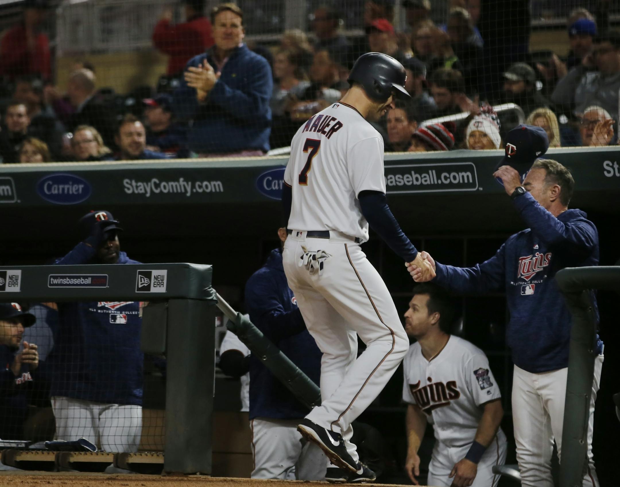 Joe Mauer scores and is congratulated for passing Harmon Killebrew for most bases .