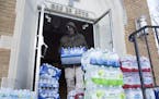 Maurice Rice organizes cases of water at the Joy Tabernacle Church on Monday, Jan. 11, 2016, in Flint, Mich. Michigan Gov. Rick Snyder pledged Monday 