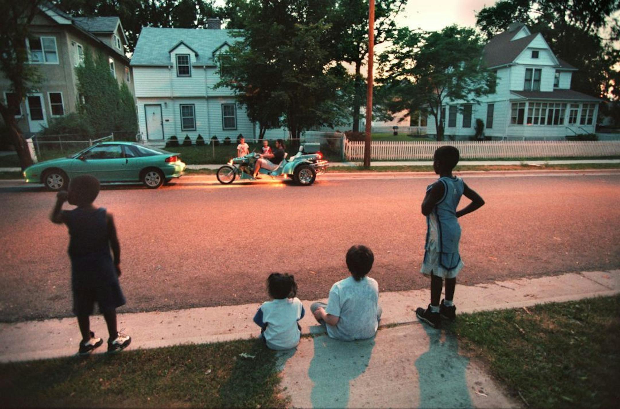1996: On a warm summer night, kids gathered on the curb on the 2600 block of Colfax Avenue N. to watch as a neighbor tried out a new motortricycle.