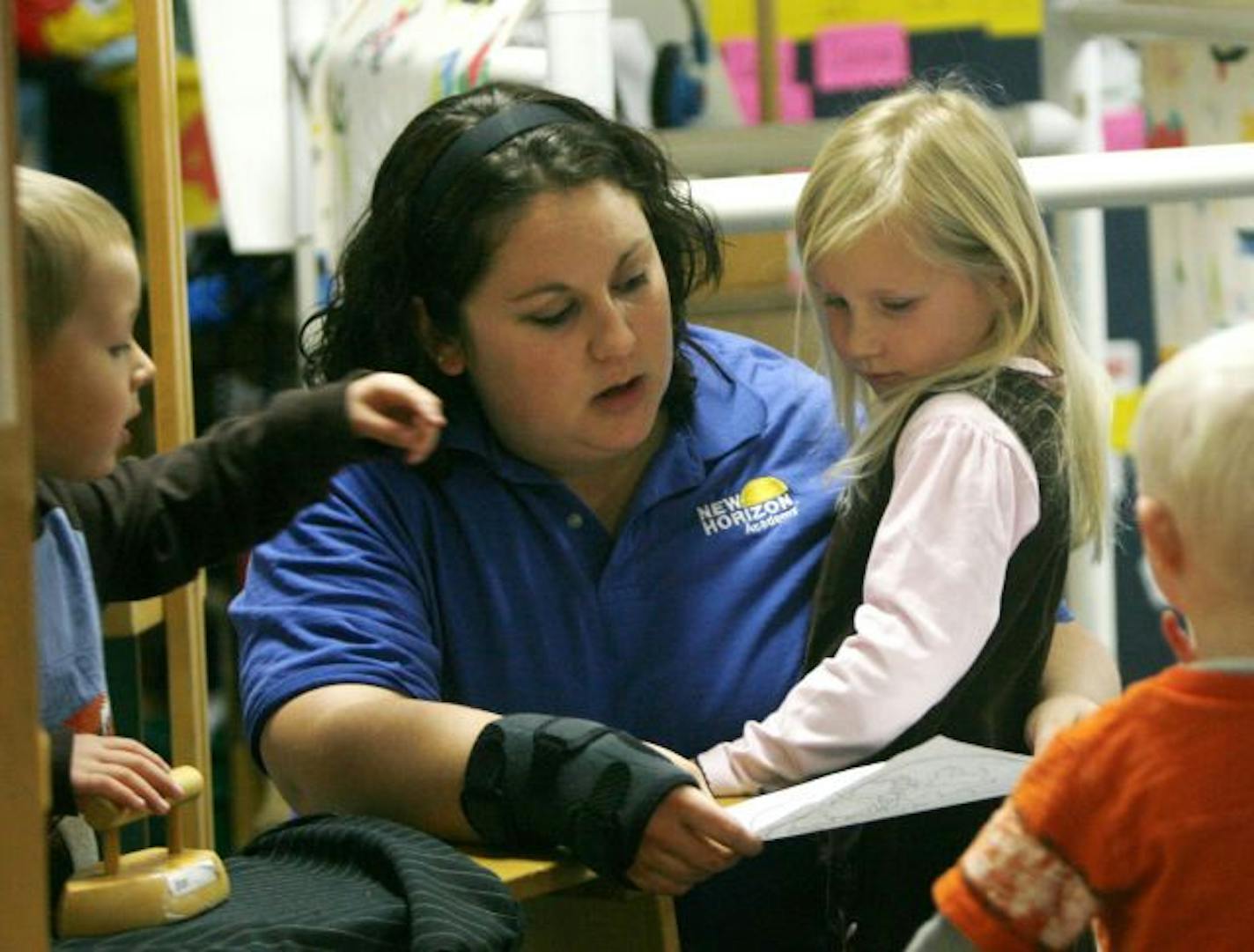 Child care authorities are beginning to tackle a long-known dilemma in Minnesota: the high cost of center-based child care. Authorities have always worried about lowering costs in a way that could sacrifice quality, but fear that the cost issue has only gotten worse due to the recession. The high cost may be preserving quality, but now it also might be pricing too many families out of the market.
In this photo:] Maesa Stickney, right, shows her art work to pre-kindergarten teacher Jaci Greninger